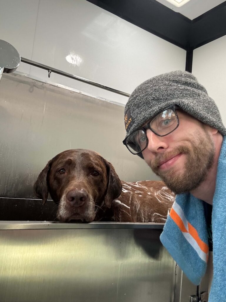 Steven bathing a dog at The Groomin' Cowboy Mobile Saloon