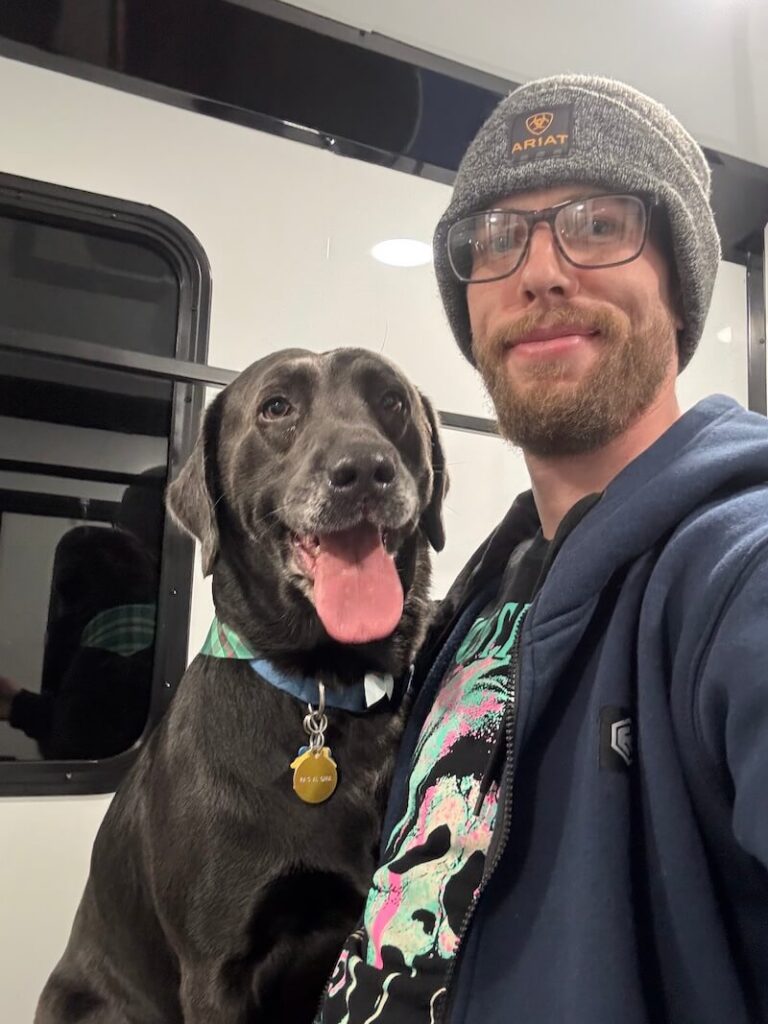 Steven posing with a happy canine customer at The Groomin' Cowboy Mobile Saloon