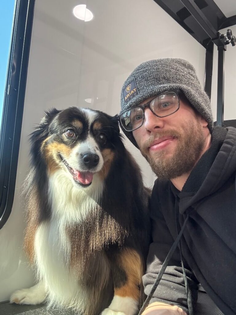 Steven posing with a happy canine customer at The Groomin' Cowboy Mobile Saloon