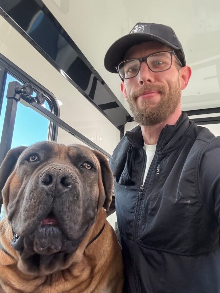 Steven posing with a happy canine customer at The Groomin' Cowboy Mobile Saloon