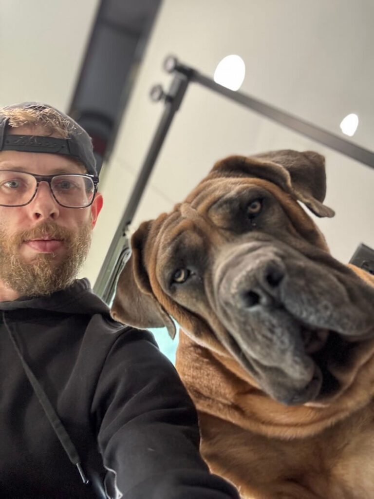 Steven posing with a happy canine customer at The Groomin' Cowboy Mobile Saloon